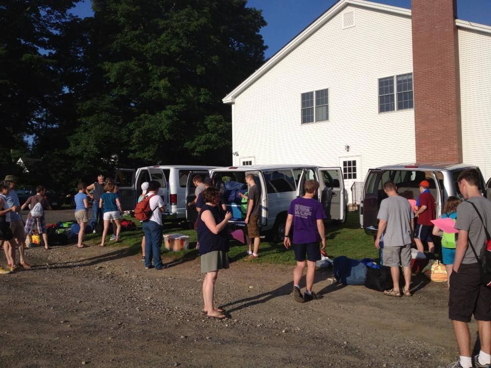 People Loading Luggage Into Vans Outside a White Building — Amherst, MA — Immanuel Lutheran Church People Loading Luggage Into Vans Outside a White Building — Amherst, MA — Immanuel Lutheran Church