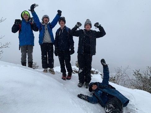 Five People in Winter Clothes Celebrate in The Snow — Amherst, MA — Immanuel Lutheran Church
