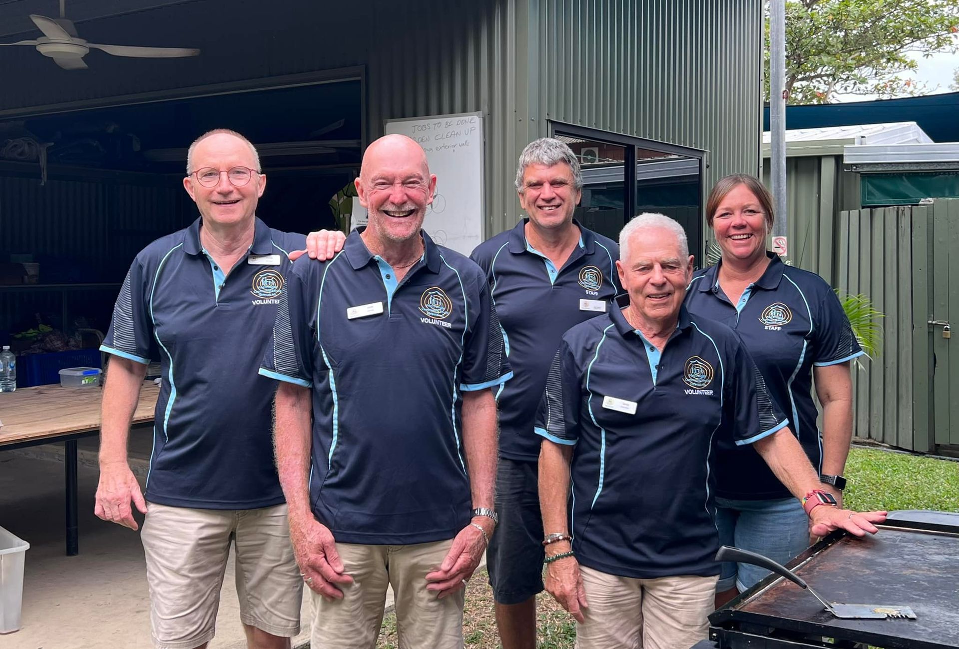 A group of people are posing for a picture in front of a building.