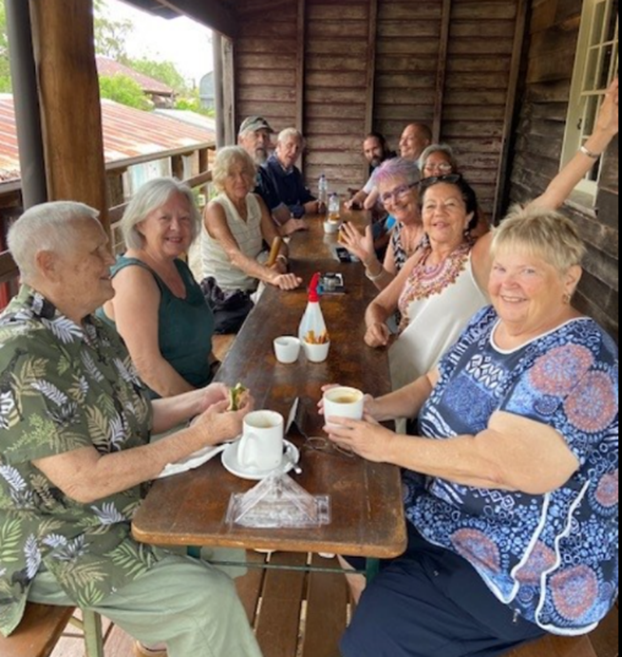 A group of people are sitting at a table eating and drinking