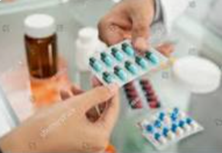 A person is holding a blister pack of pills in their hand.