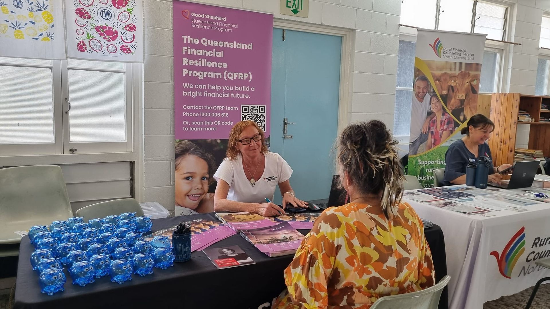 A woman is sitting at a table talking to another woman.