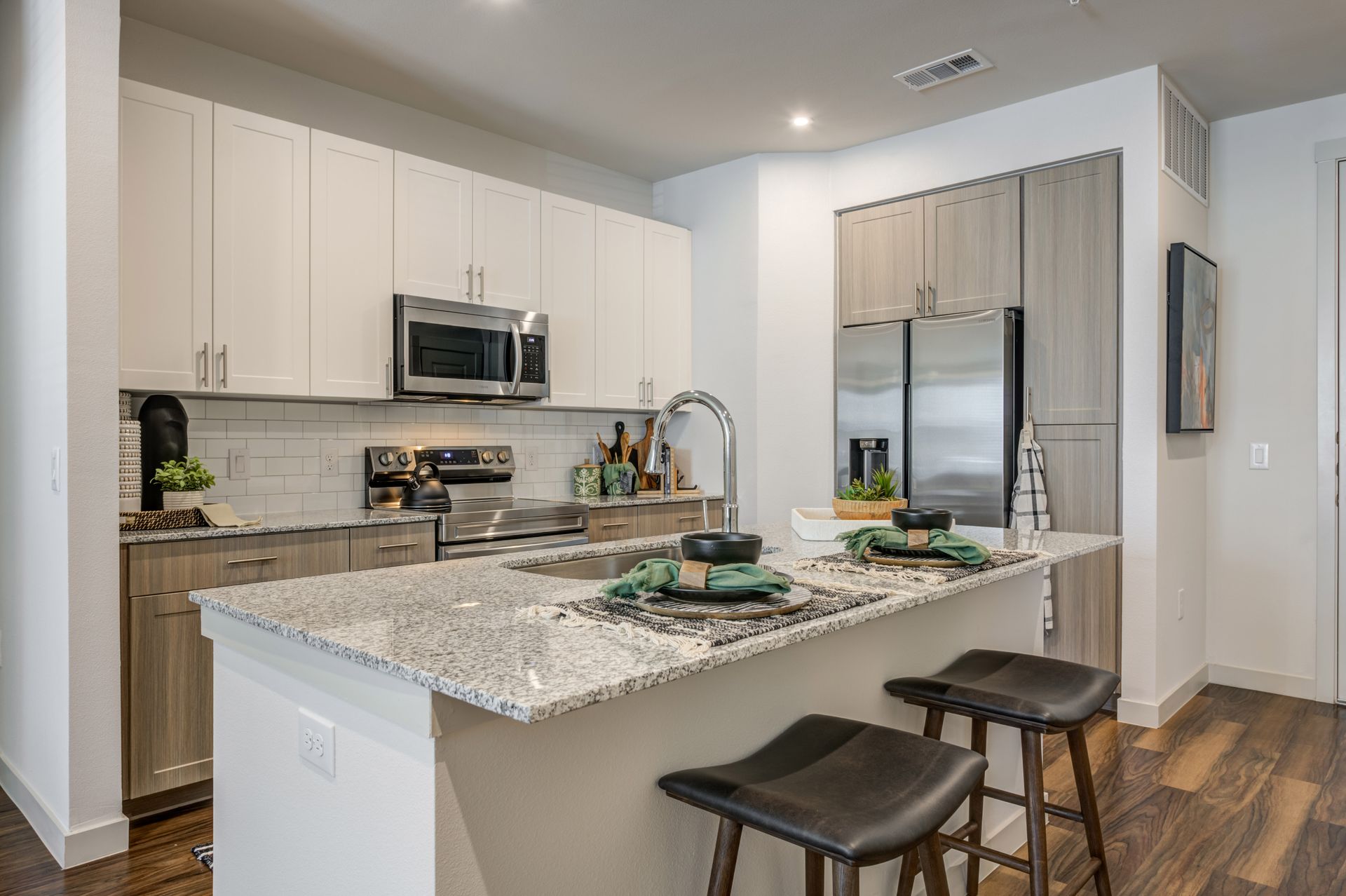 A kitchen with granite counter tops , stainless steel appliances , and a large island at The Jameson.