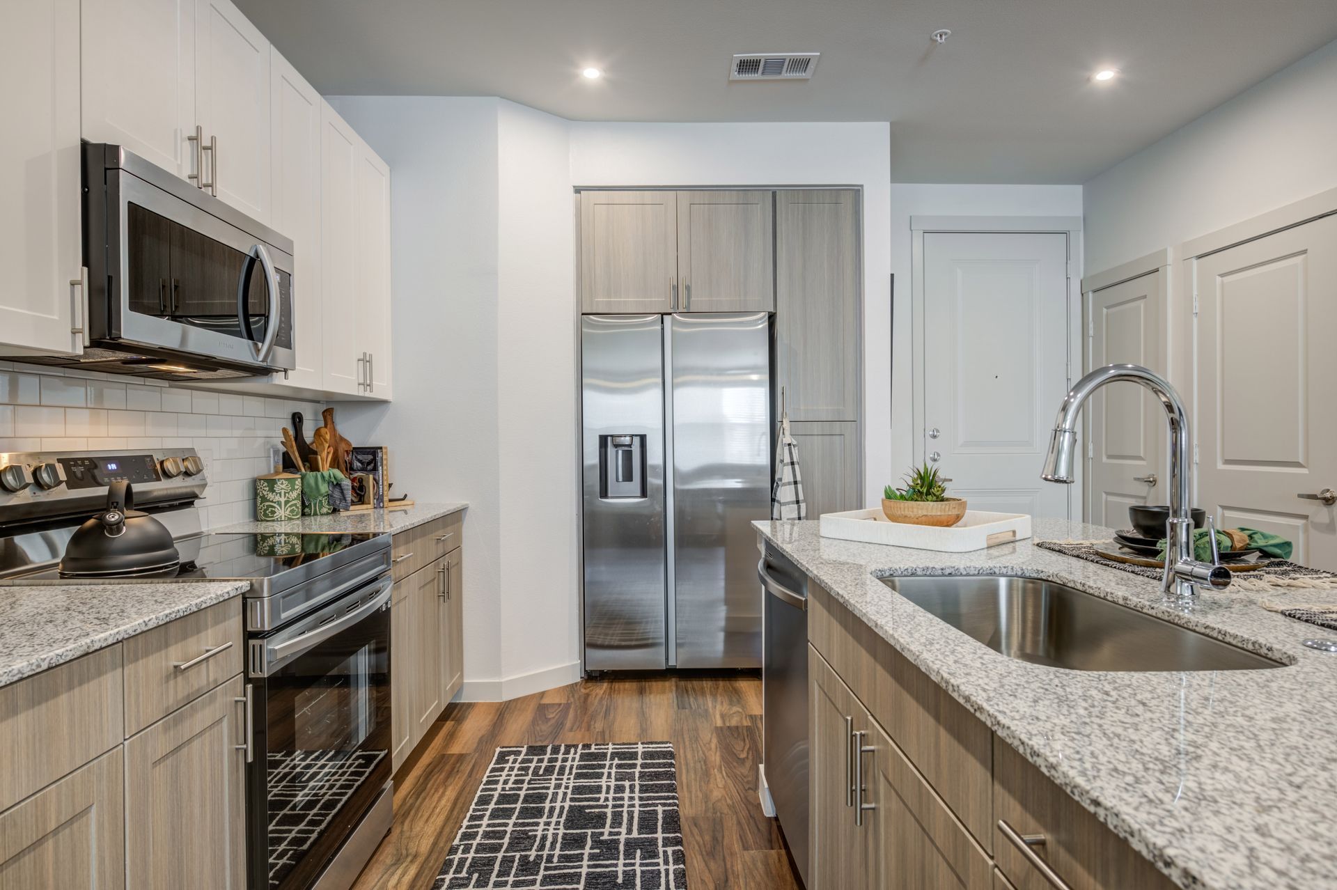 A kitchen with stainless steel appliances and granite counter tops at The Jameson.