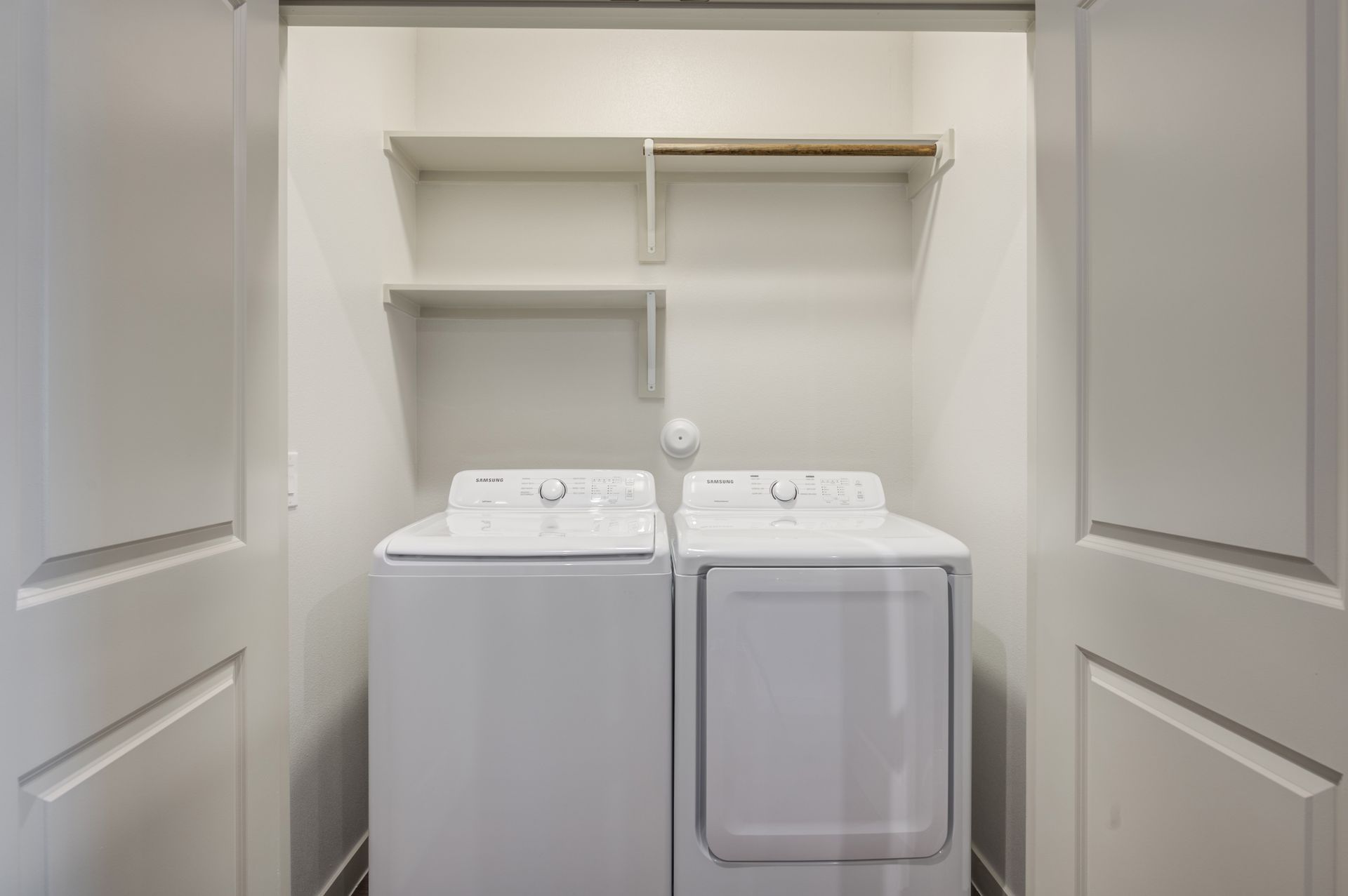 A laundry room with a washer and dryer in a closet at The Jameson.