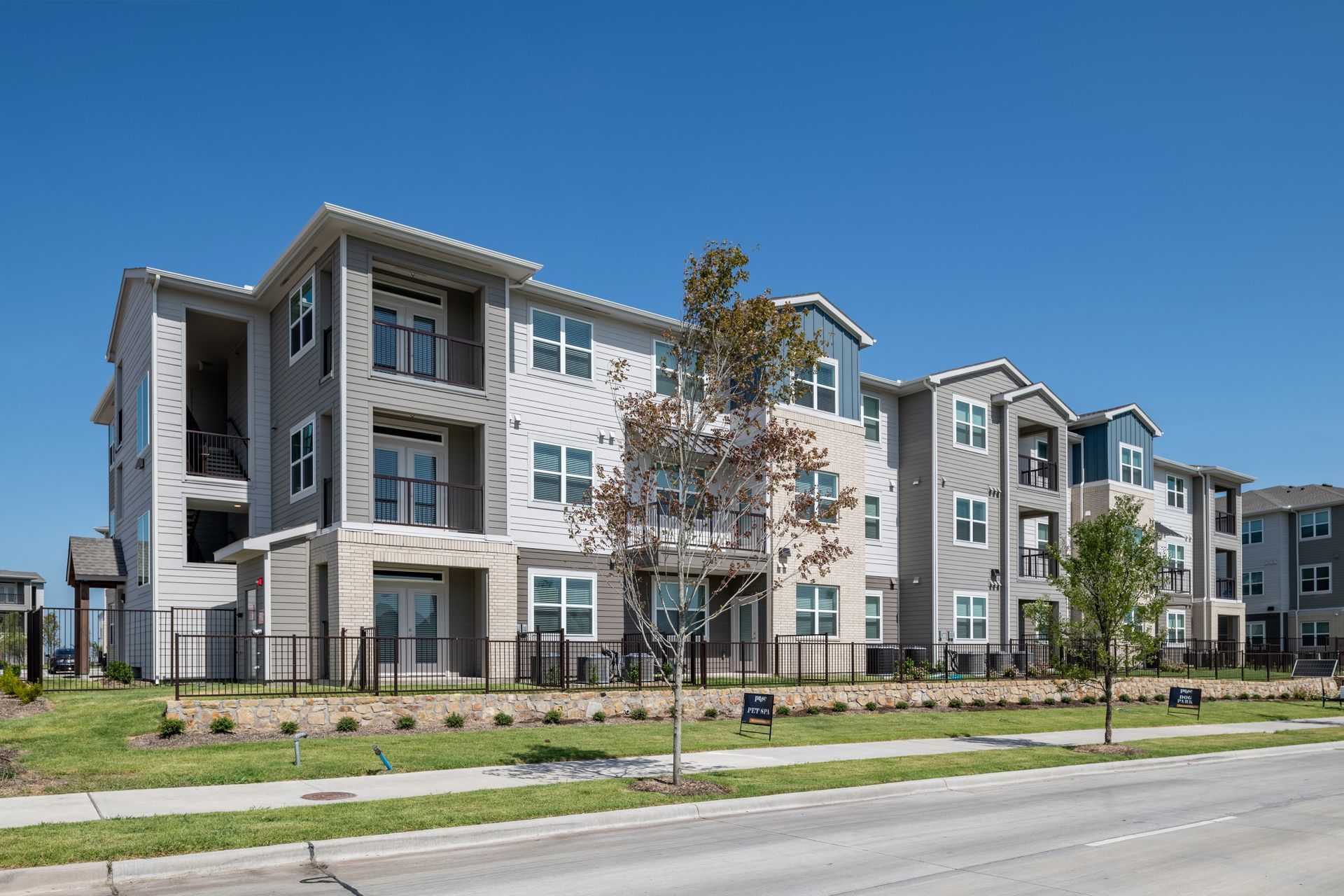 A large apartment building with a lot of windows is sitting next to a street at The Jameson.