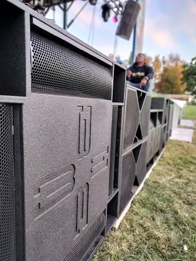Line array speaker system outdoors. Person in background.