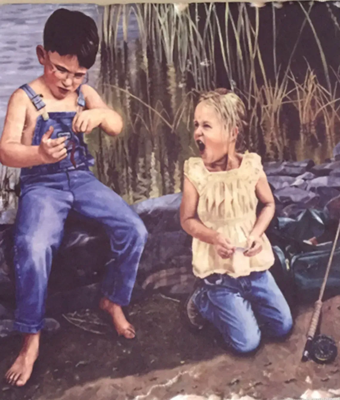 Two children outdoors, one holding a blue toy and the other laughing while kneeling near tall grass.