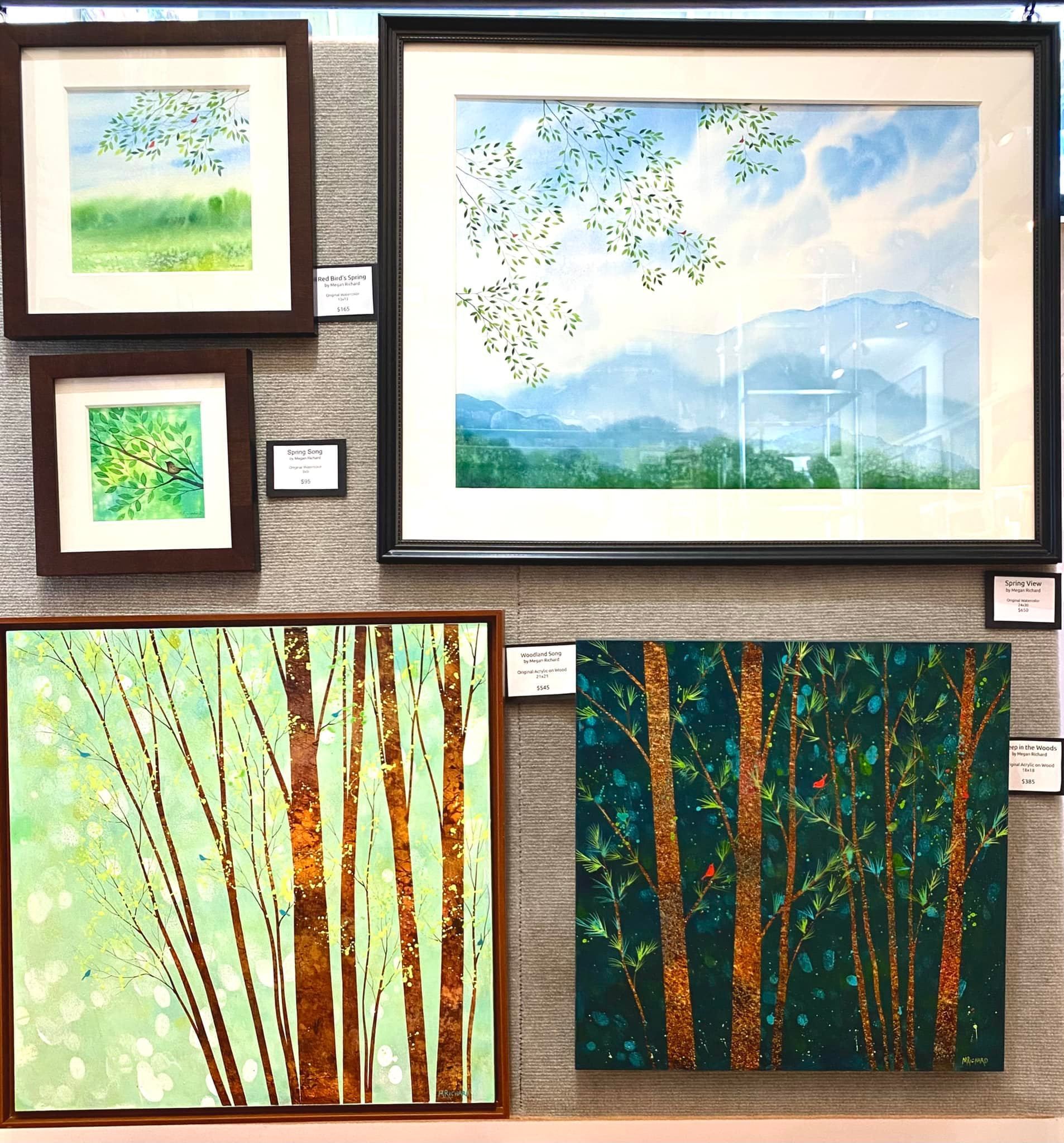 Framed landscape paintings of trees, birds, and mountains displayed on a textured wall.