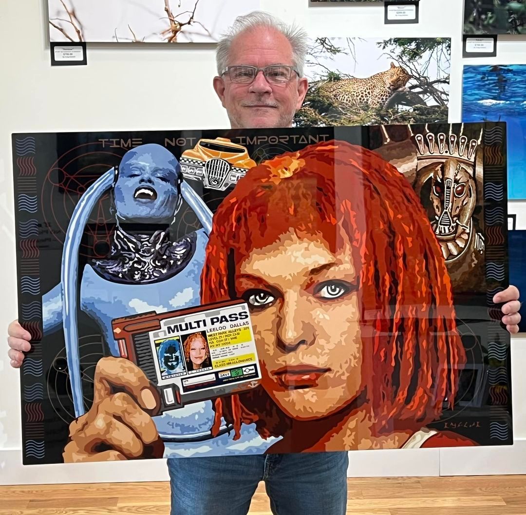 Man holding a colorful collage poster with a red-haired woman and a badge in the foreground