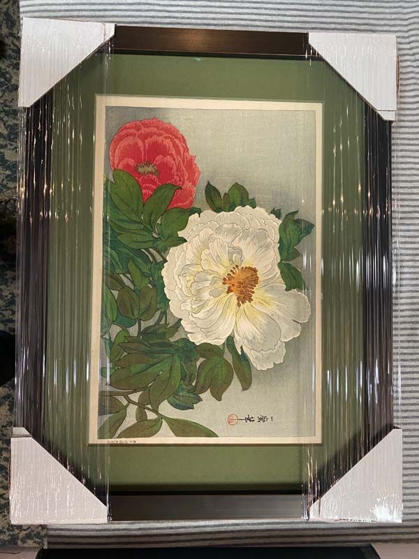 Framed floral painting with a red and white flower and green leaves, wrapped in protective packaging.