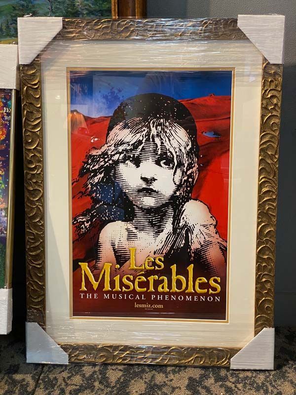 Framed Les Misérables poster with a black-and-white portrait against a red background
