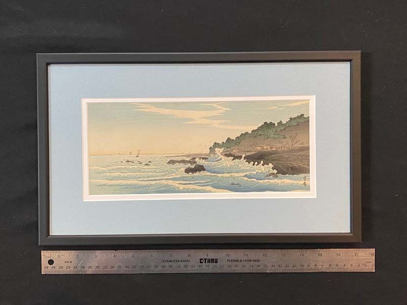 Framed seascape painting in muted pastels, hung above a ruler for size reference.