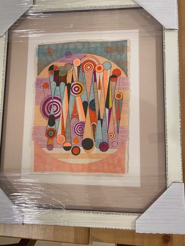 Framed abstract artwork with colorful circles and vertical shapes in pink, orange, teal, and black