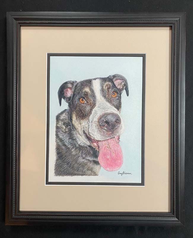 Framed watercolor portrait of a black-and-white dog with a pink tongue on a beige mat