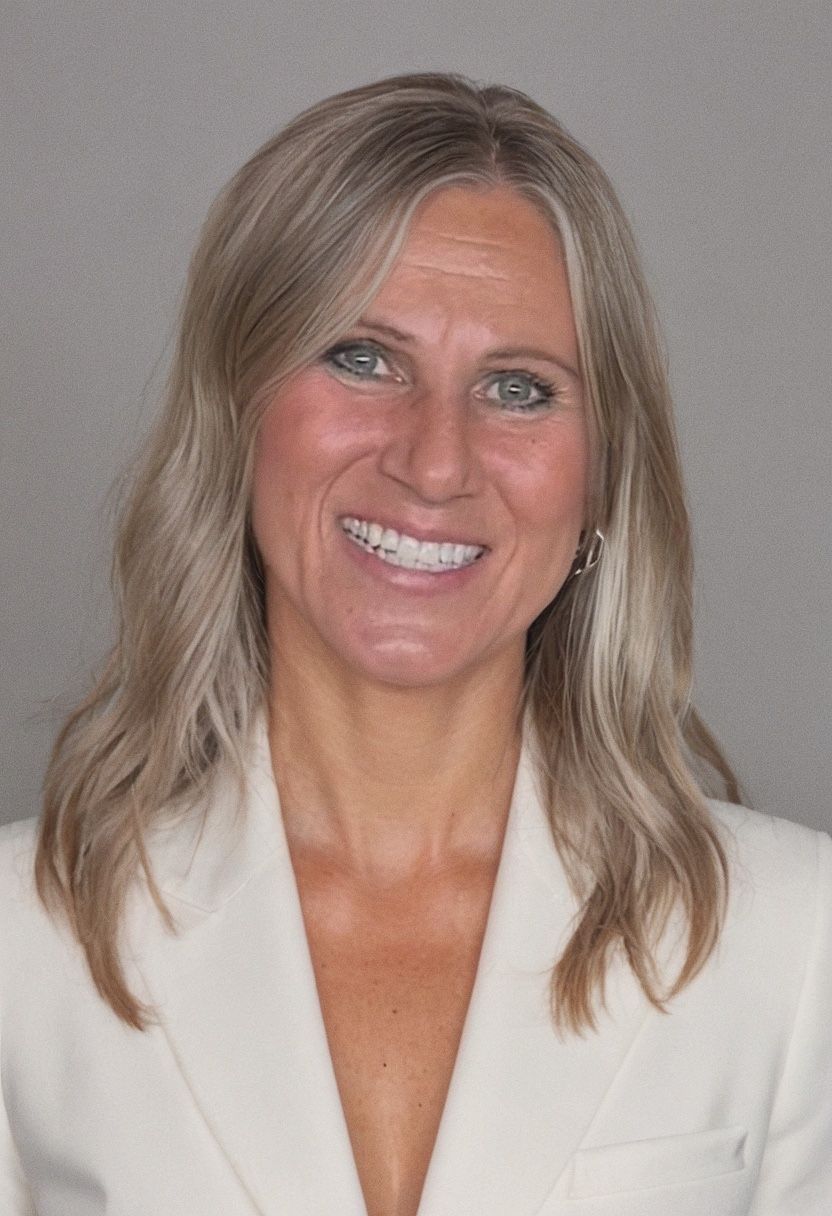 Studio headshot of a smiling blonde woman in a light blue blouse