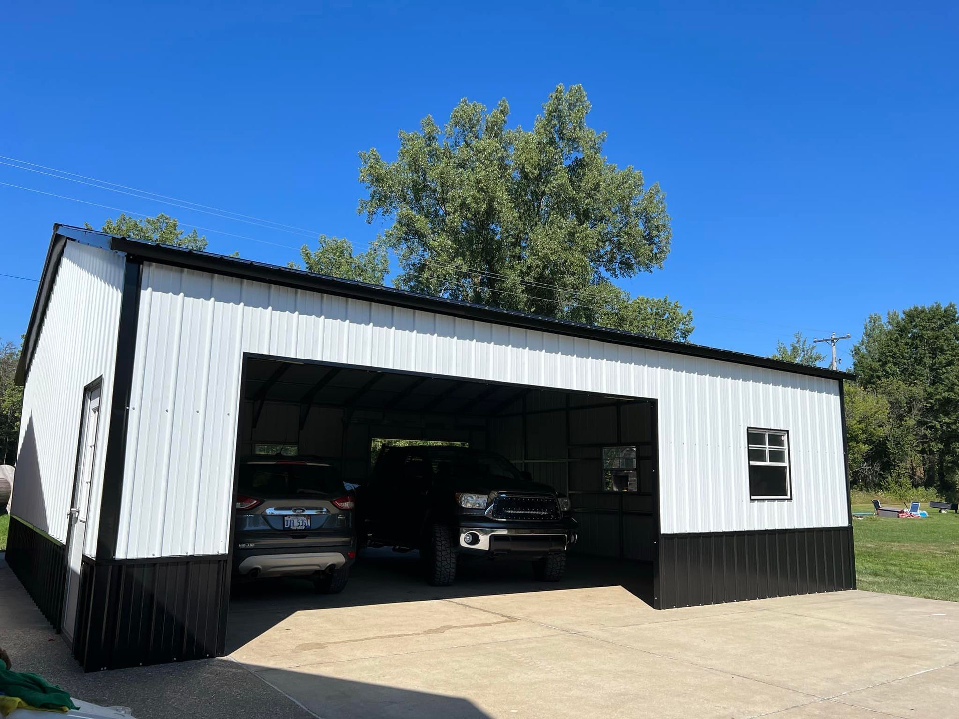 A black and white garage with two cars parked inside of it