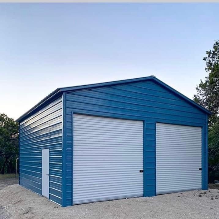 A blue metal garage with two white garage doors