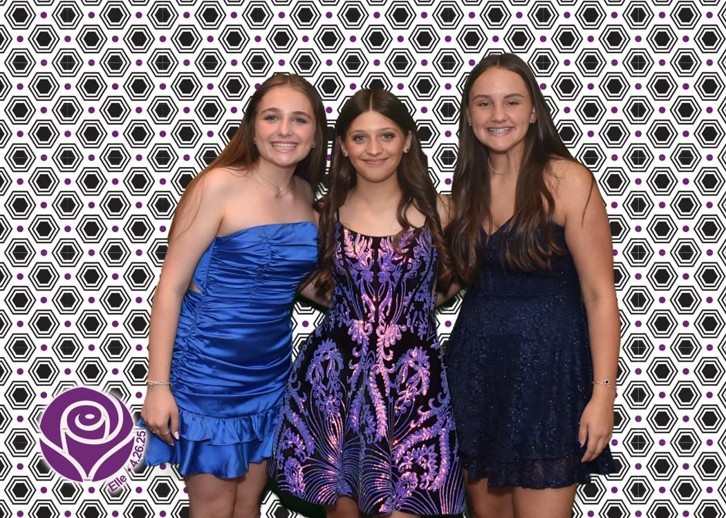 Three young women smiling in formal dresses pose in front of a patterned backdrop.