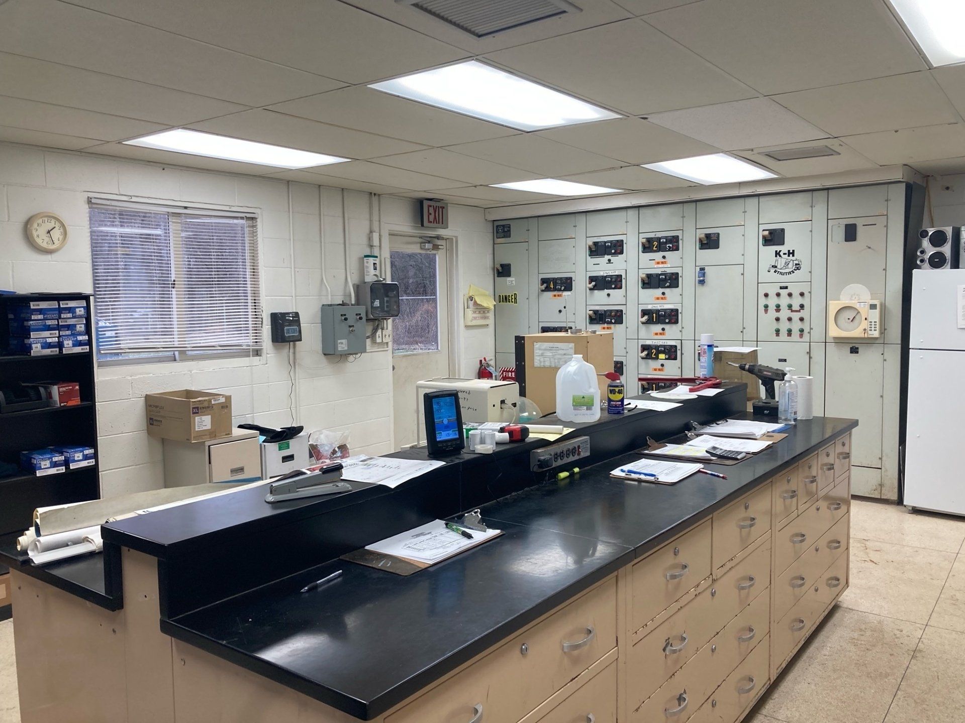 A laboratory with a long counter and a refrigerator