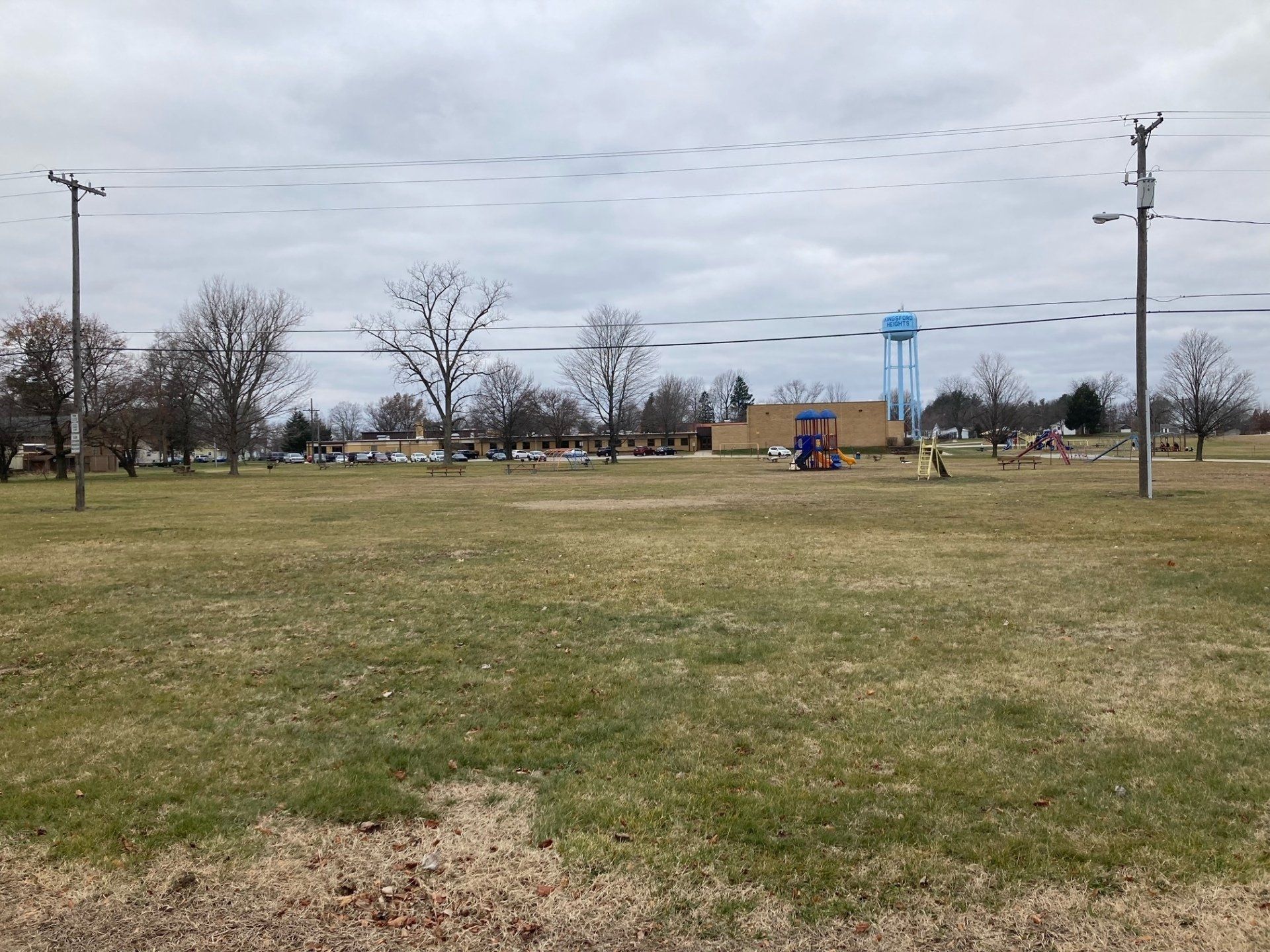 A large grassy field with a water tower in the background.
