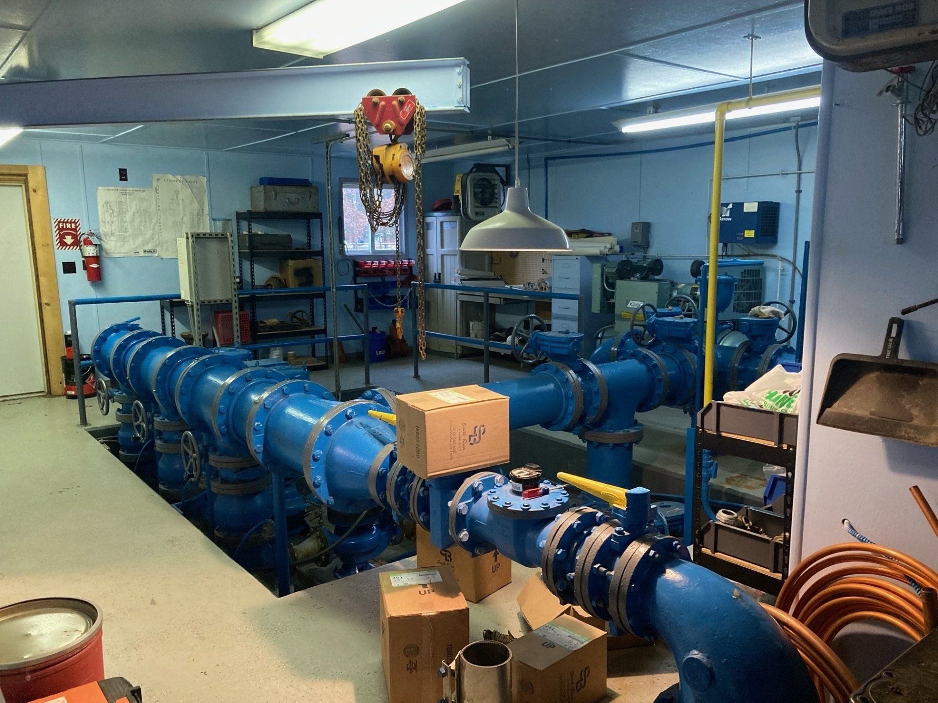 A room with a lot of pipes and boxes on the floor