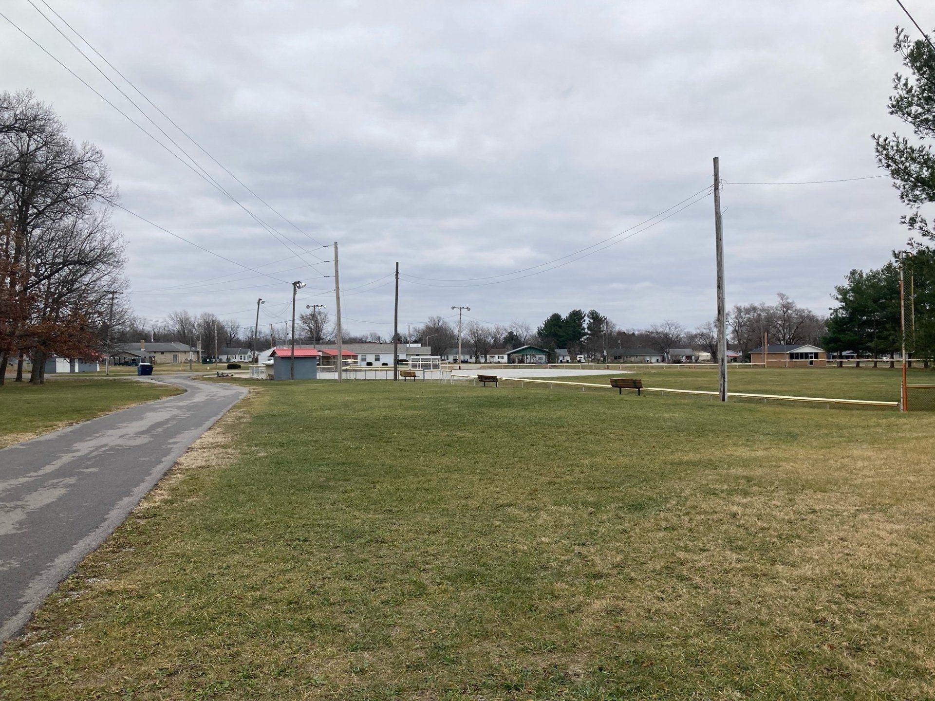 A grassy field with a road going through it