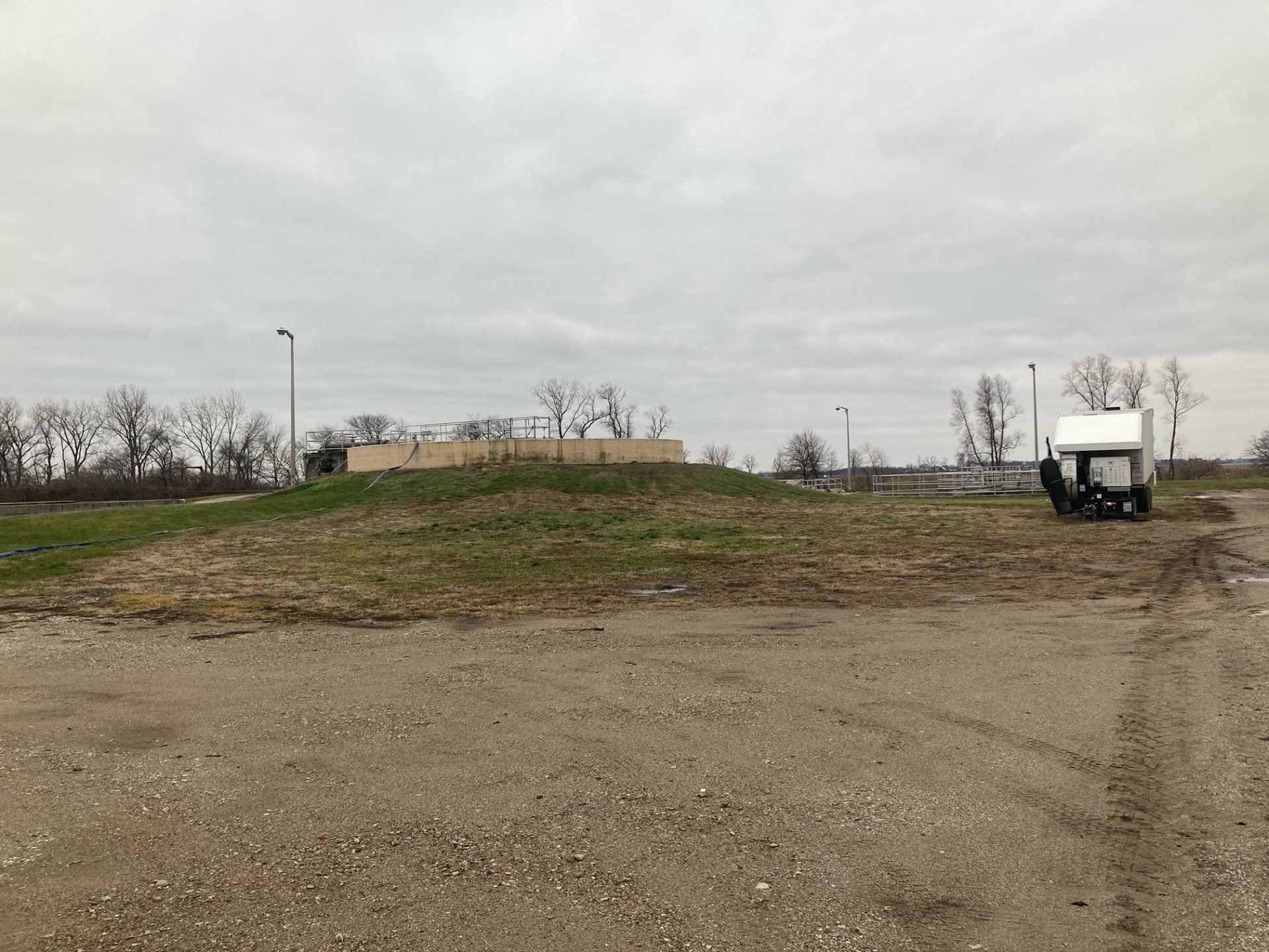 A large dirt field with a building in the background.