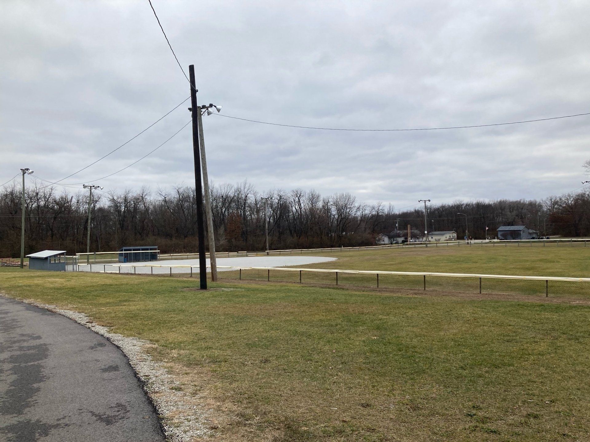 A road going through a grassy field with trees in the background