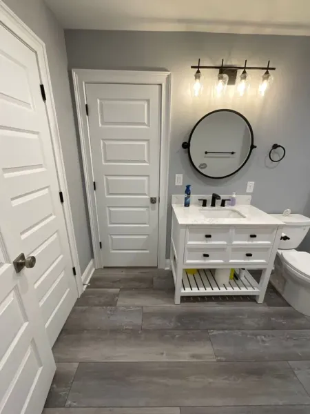 A bathroom with a sink , toilet and mirror.