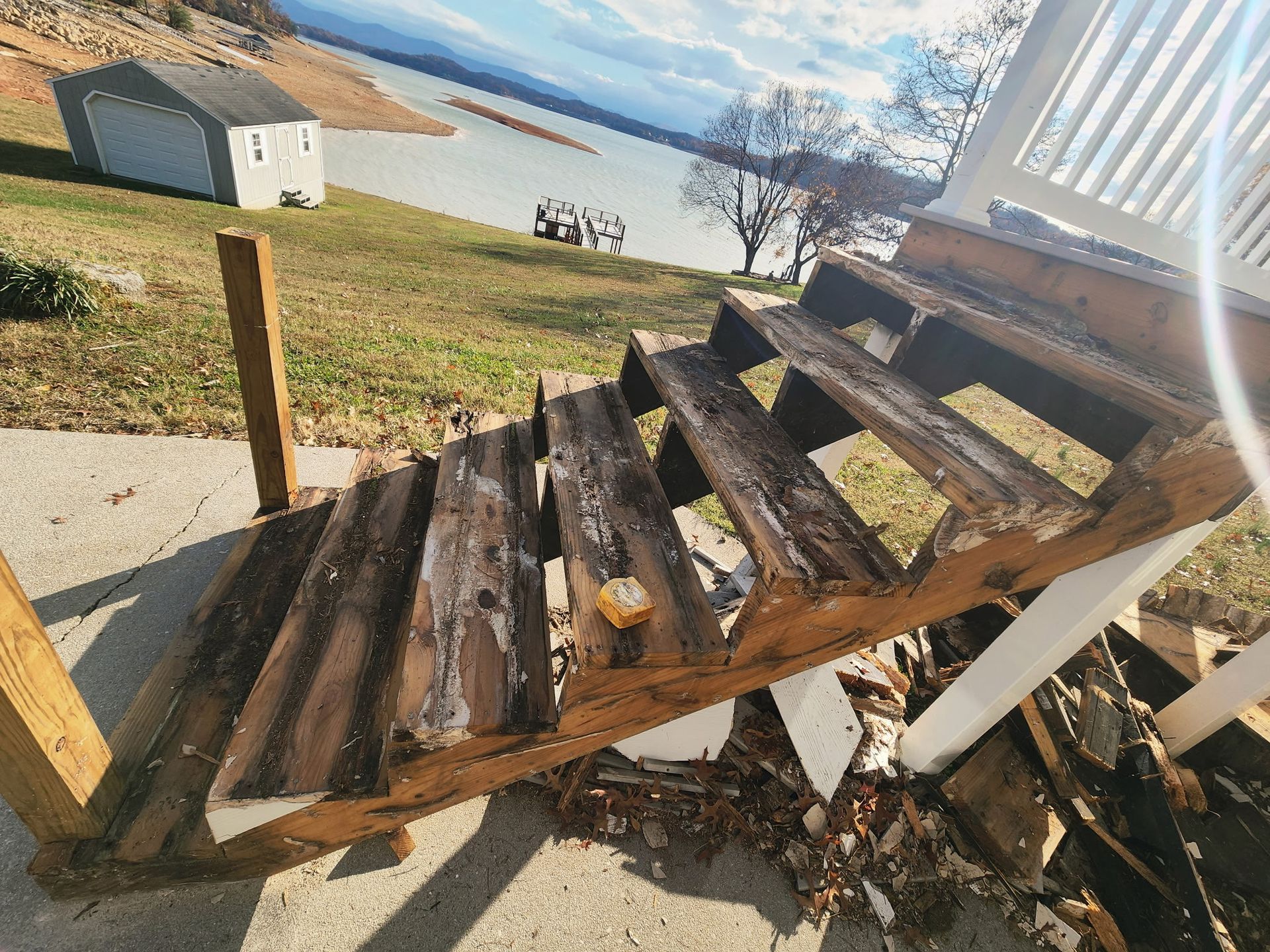 Damaged wooden outdoor stairs leading to a building, by a lake.