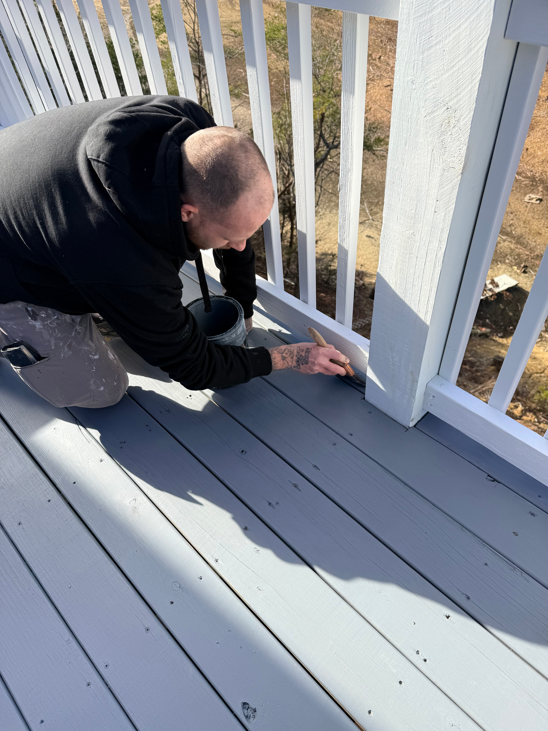 A man in a blue shirt is holding a paint roller
