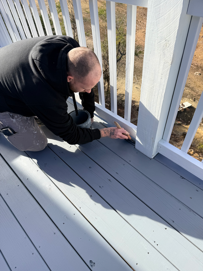 A man in a blue shirt is holding a paint roller