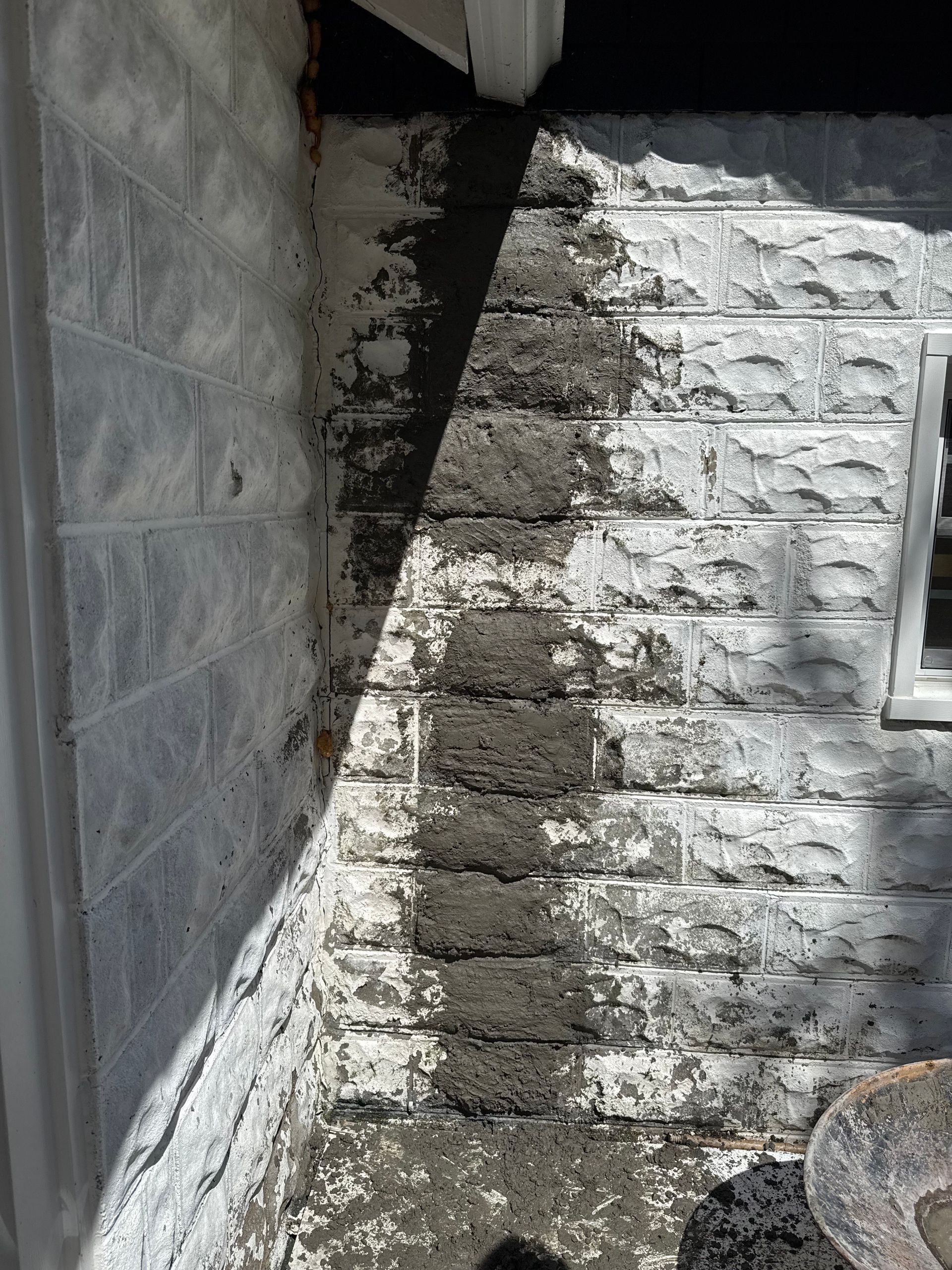 Exterior wall with a section of patched concrete. Light gray brick pattern.