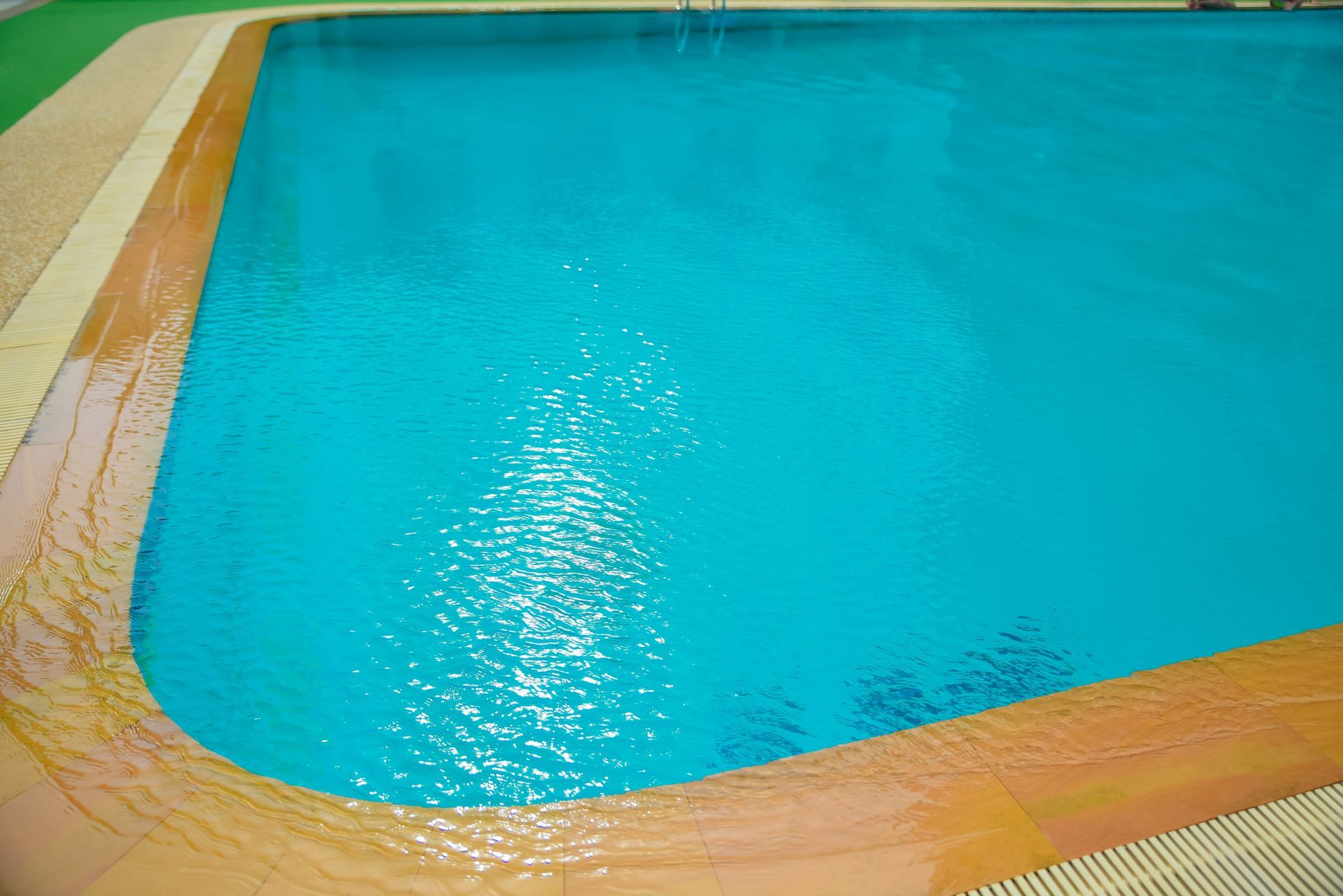 A large swimming pool in a backyard with a house in the background.