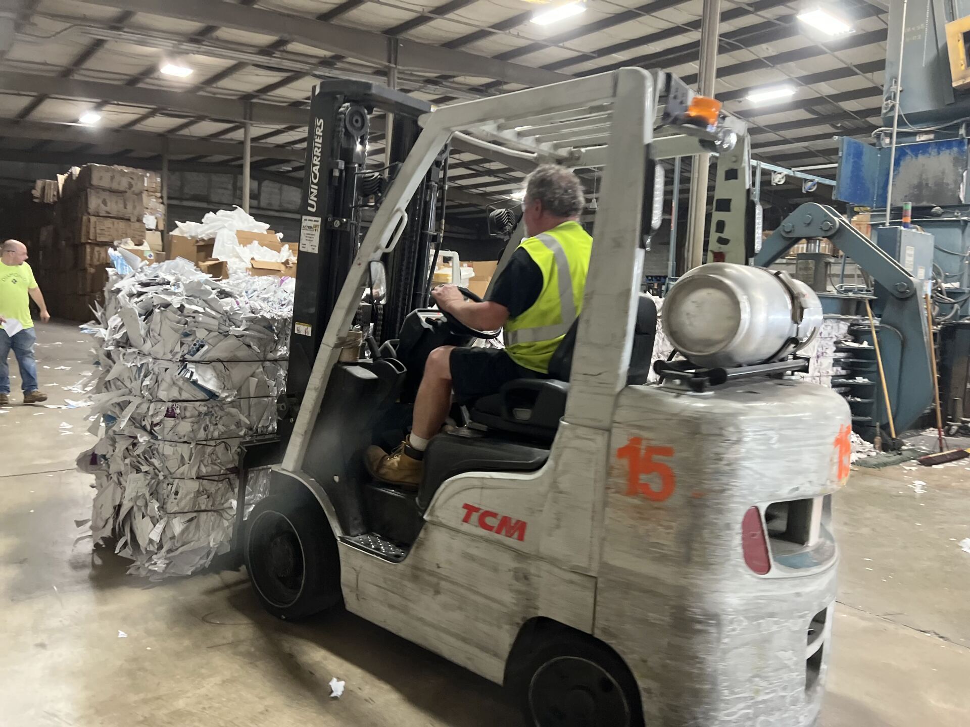 A man is driving a forklift in a warehouse.