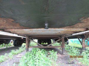 The bottom of a trailer is sitting in the grass.