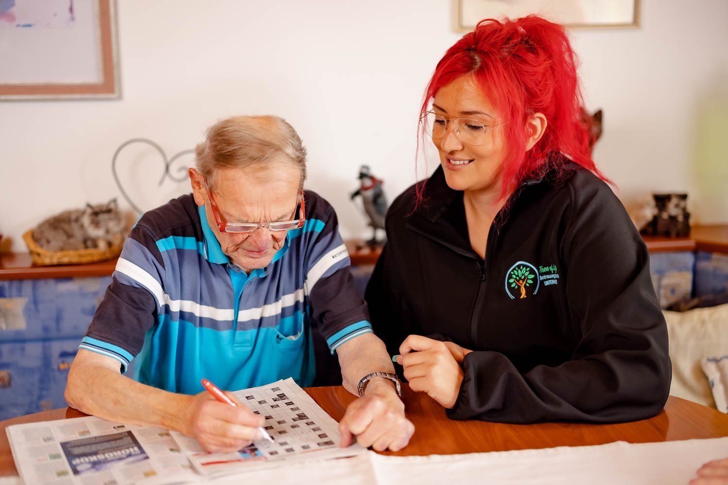 Frau Cornelia Unterweger mit einem Klienten beim Kreuzworträtsel