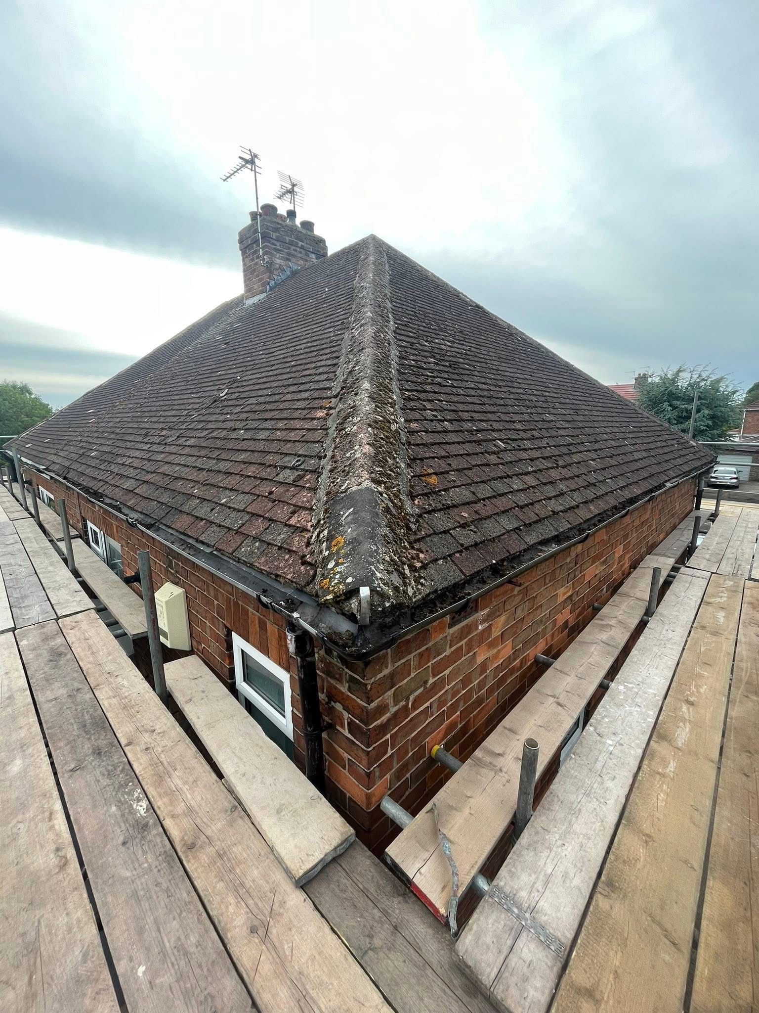 A brick building with a roof that is being repaired with scaffolding.