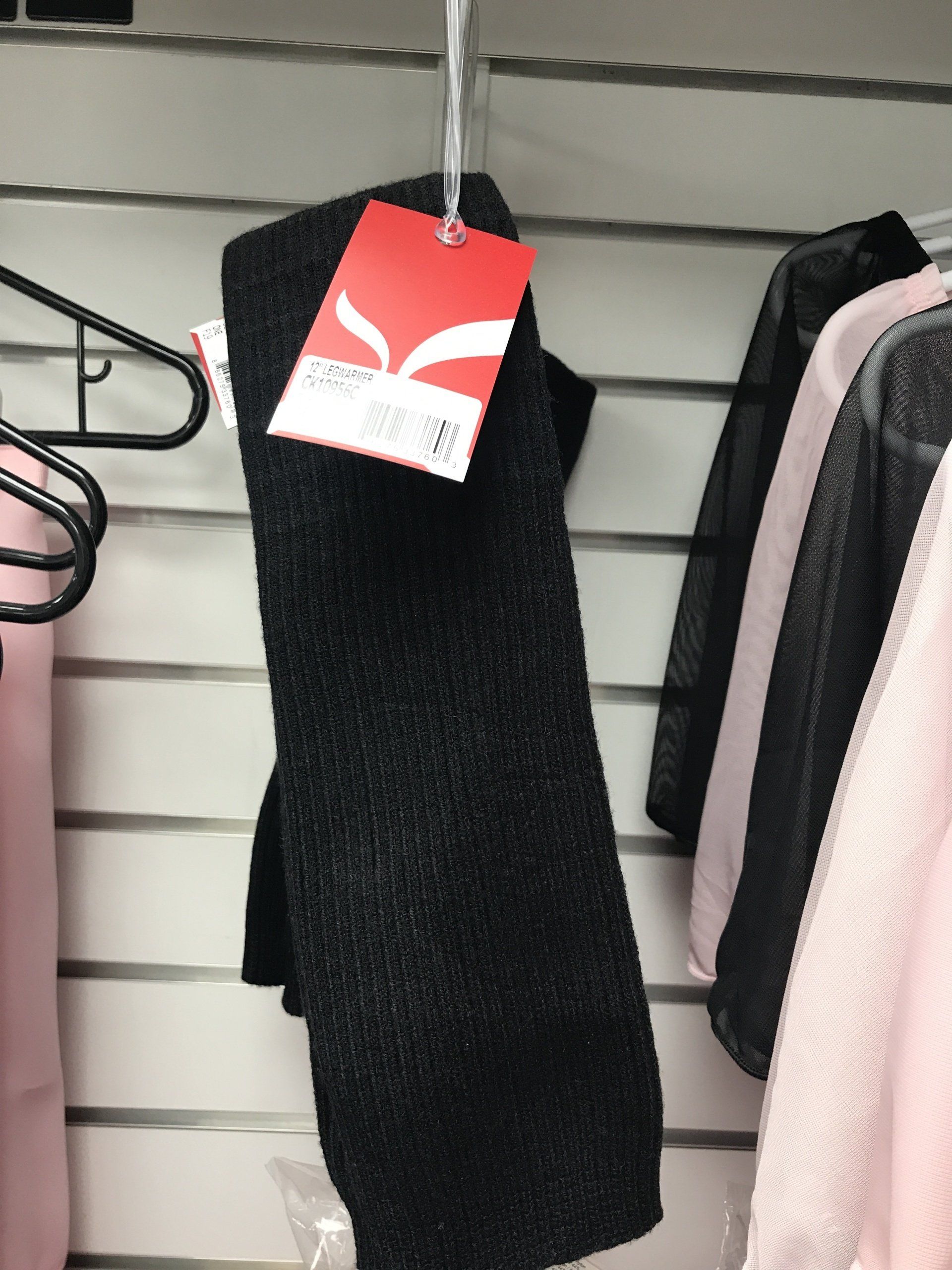A pair of black leggings with a red tag hanging on a rack