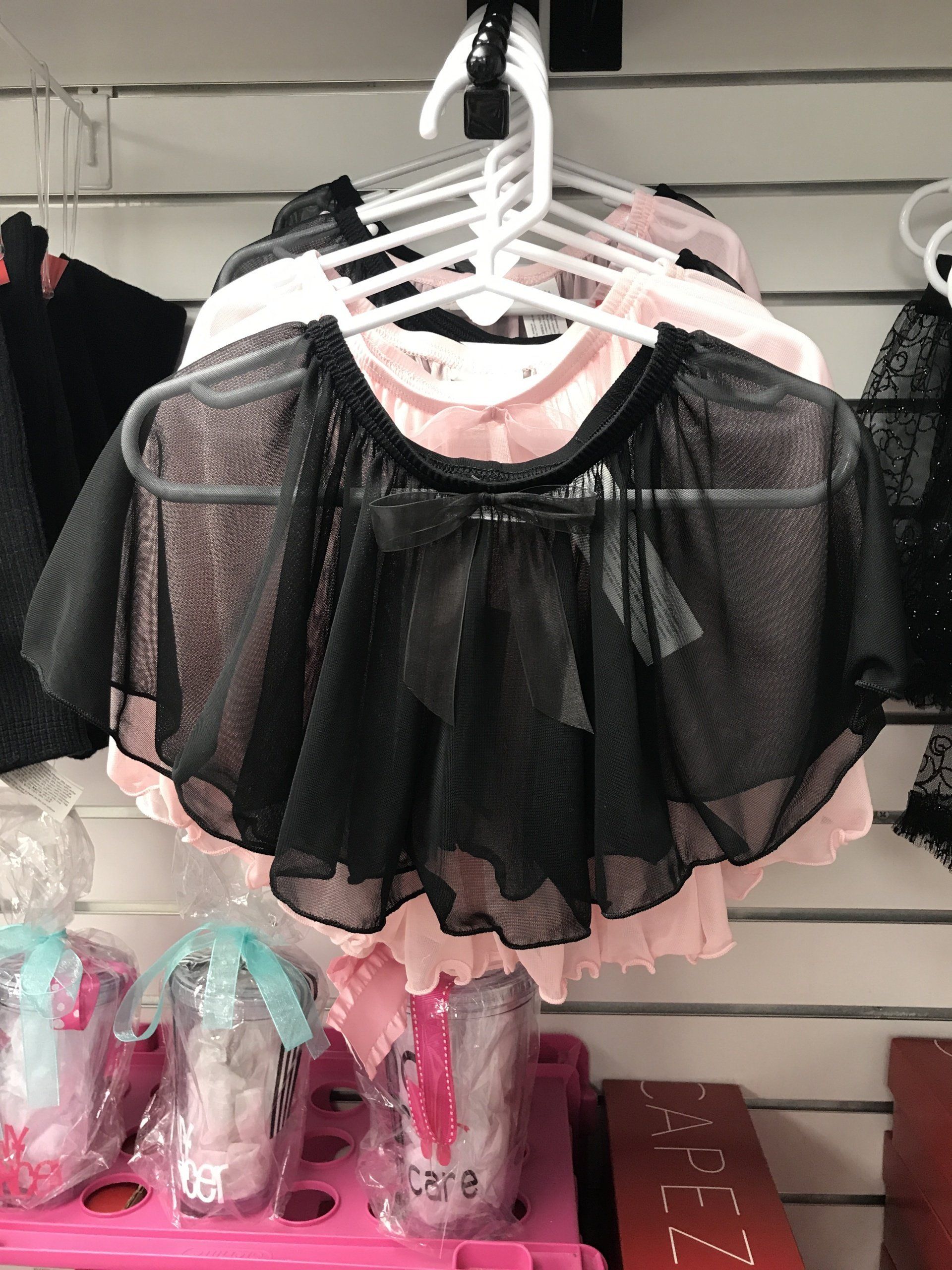 A black skirt is hanging on a hanger in a store.