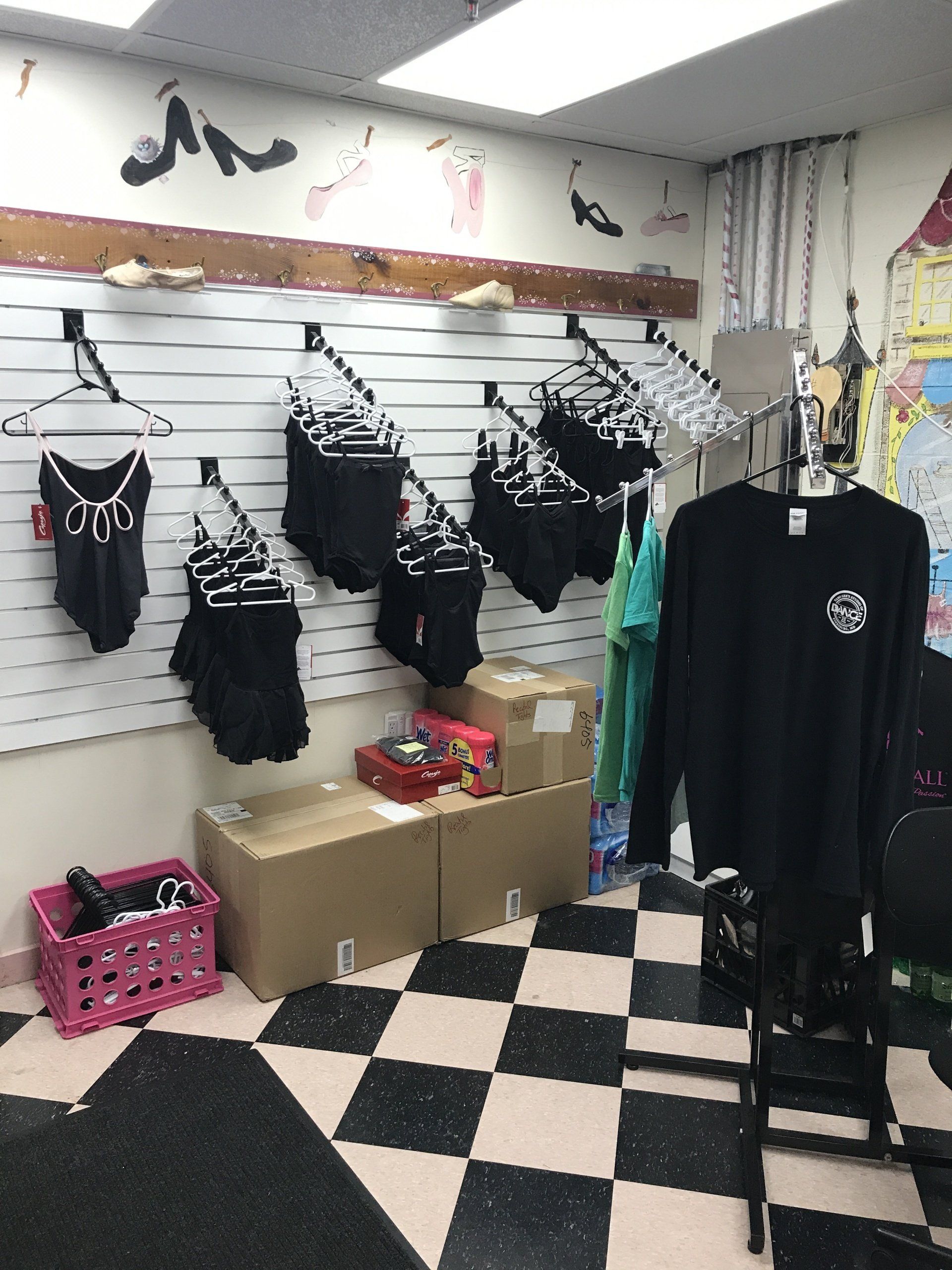 A room with clothes hanging on a wall and a checkered floor