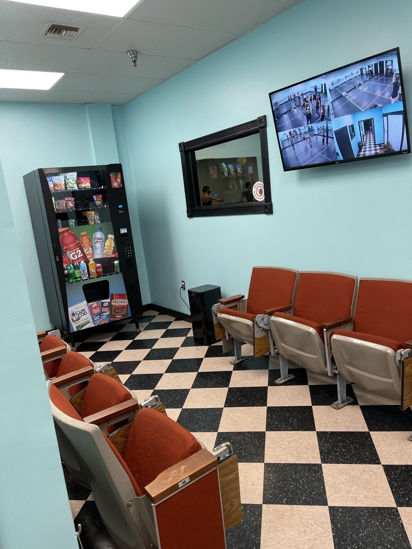 A waiting room with chairs and a vending machine.