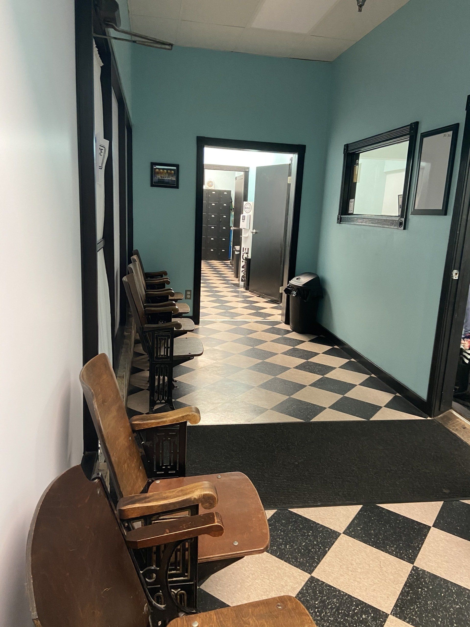 A hallway with chairs and a checkered floor