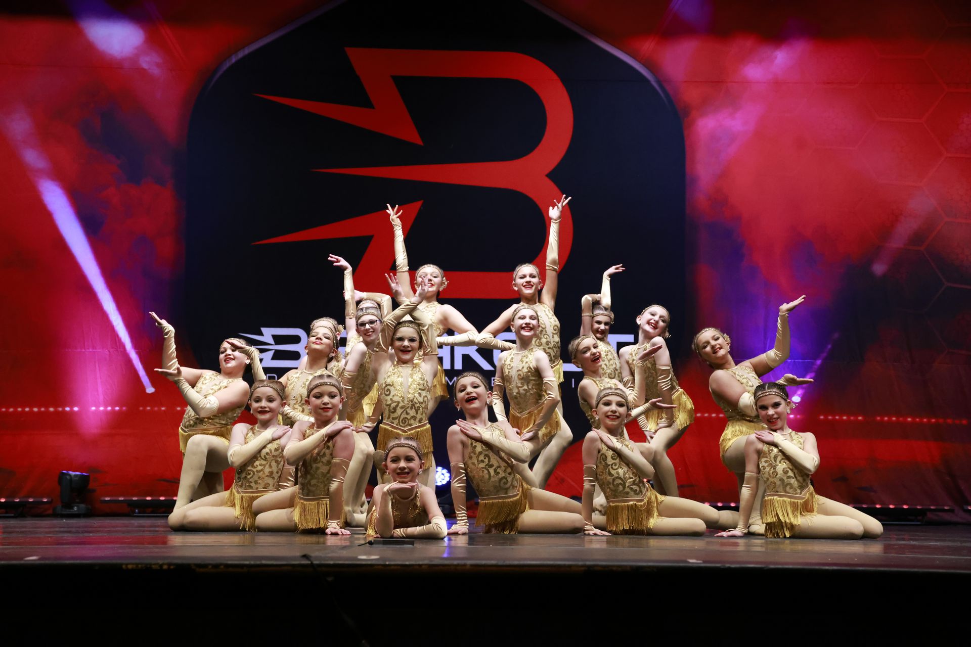 A group of young girls are posing for a picture on a stage.