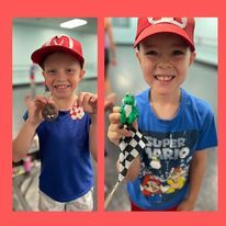 A young boy wearing a red hat and a blue shirt is holding a toy.