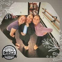 Three women are posing for a picture in a dance studio.