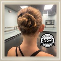 A woman is wearing a bun in a dance studio.
