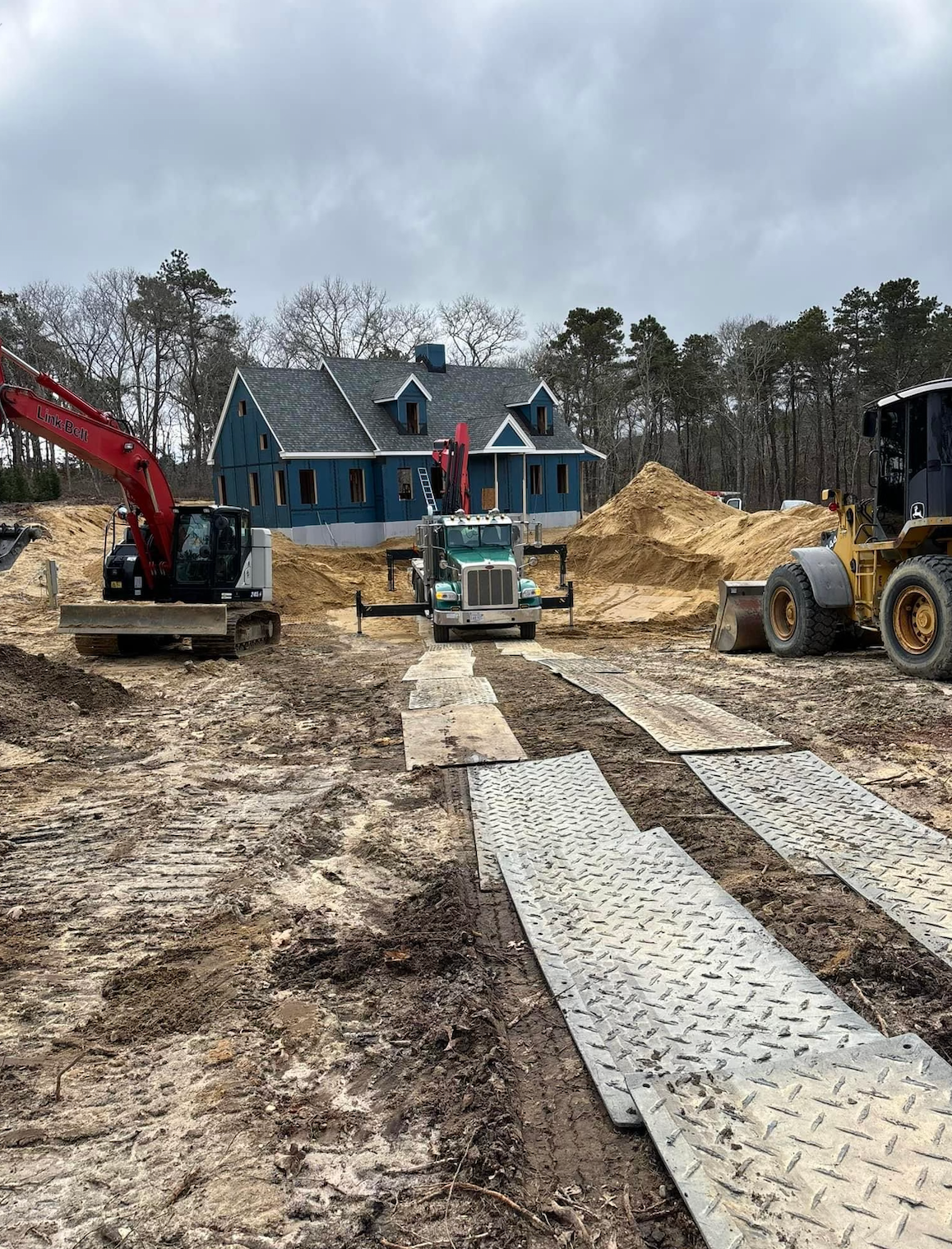 A construction site with a large house in the background.