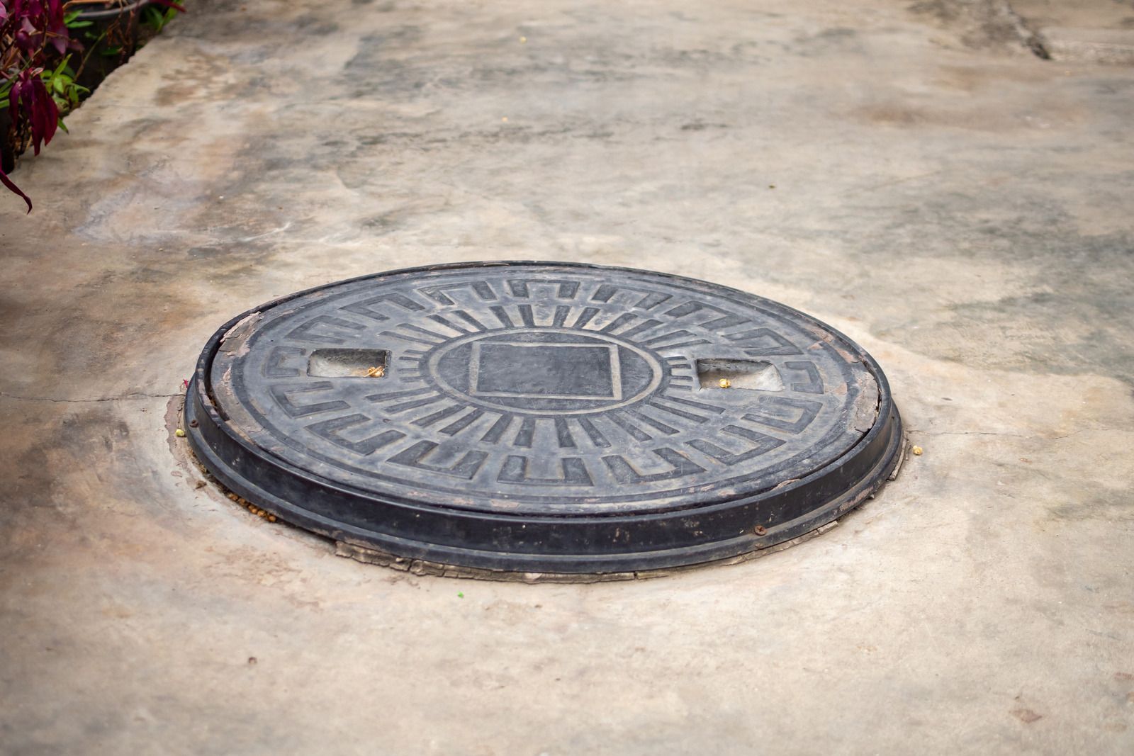 A manhole cover is sitting on a concrete surface.